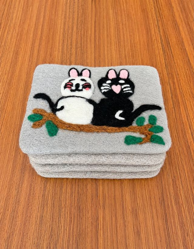Stack of embroidered felt coasters with two cats