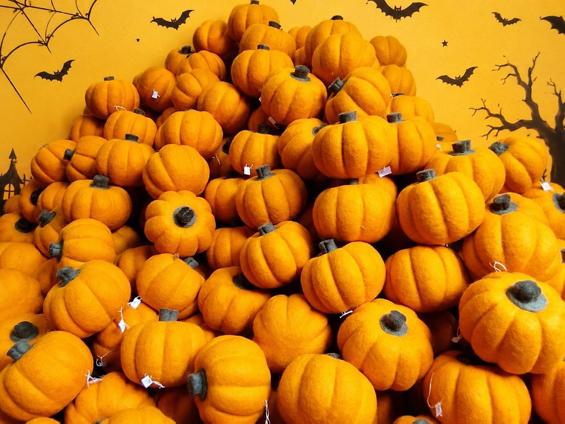 A pile of handmade orange felt pumpkins