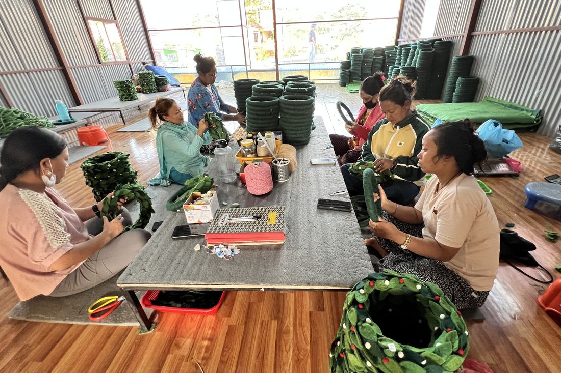 Women artisans making felt wreaths together in the workshop
