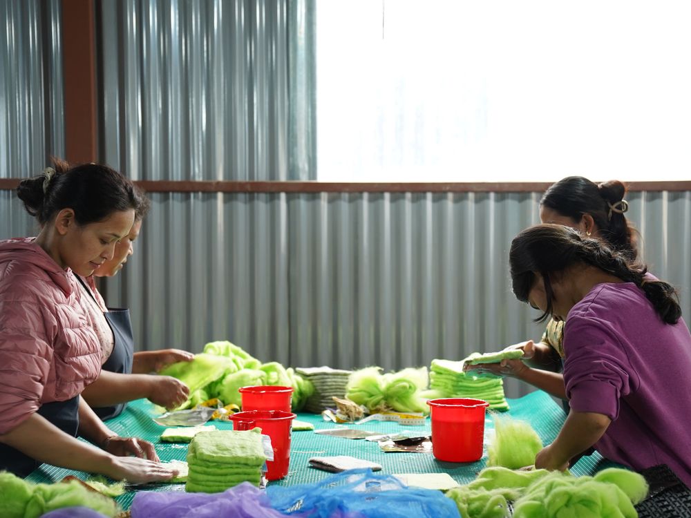 Two women artisans working together at the felting tables