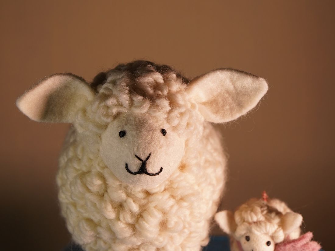 Fluffy handmade felt sheep with a small felt friend