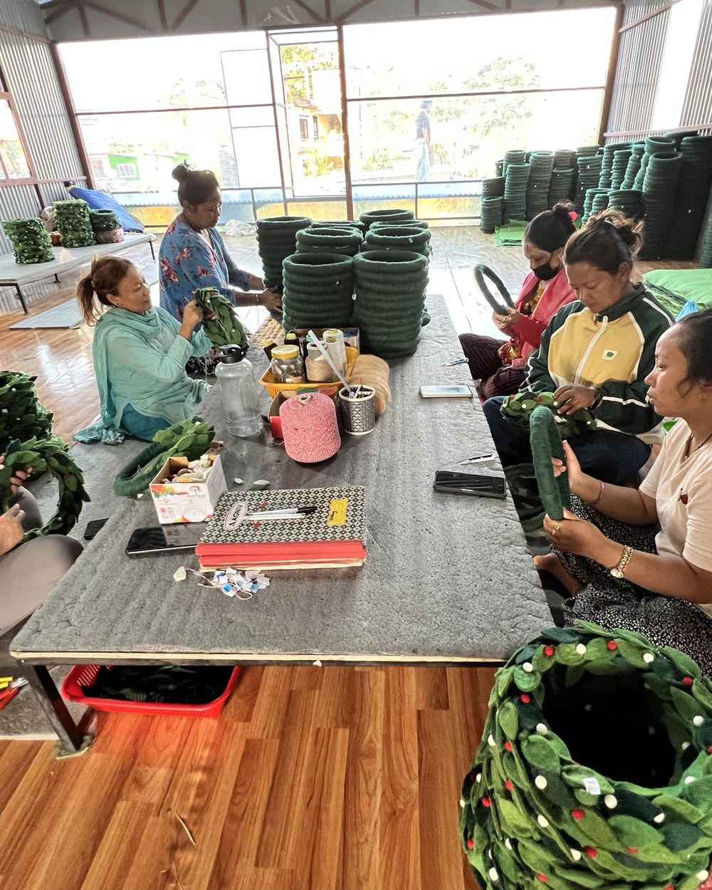 Women artisans making felt wreaths together in the workshop