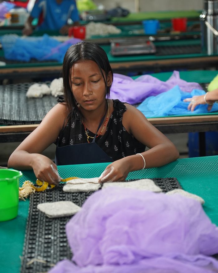 Artisan felting wool at the workshop table